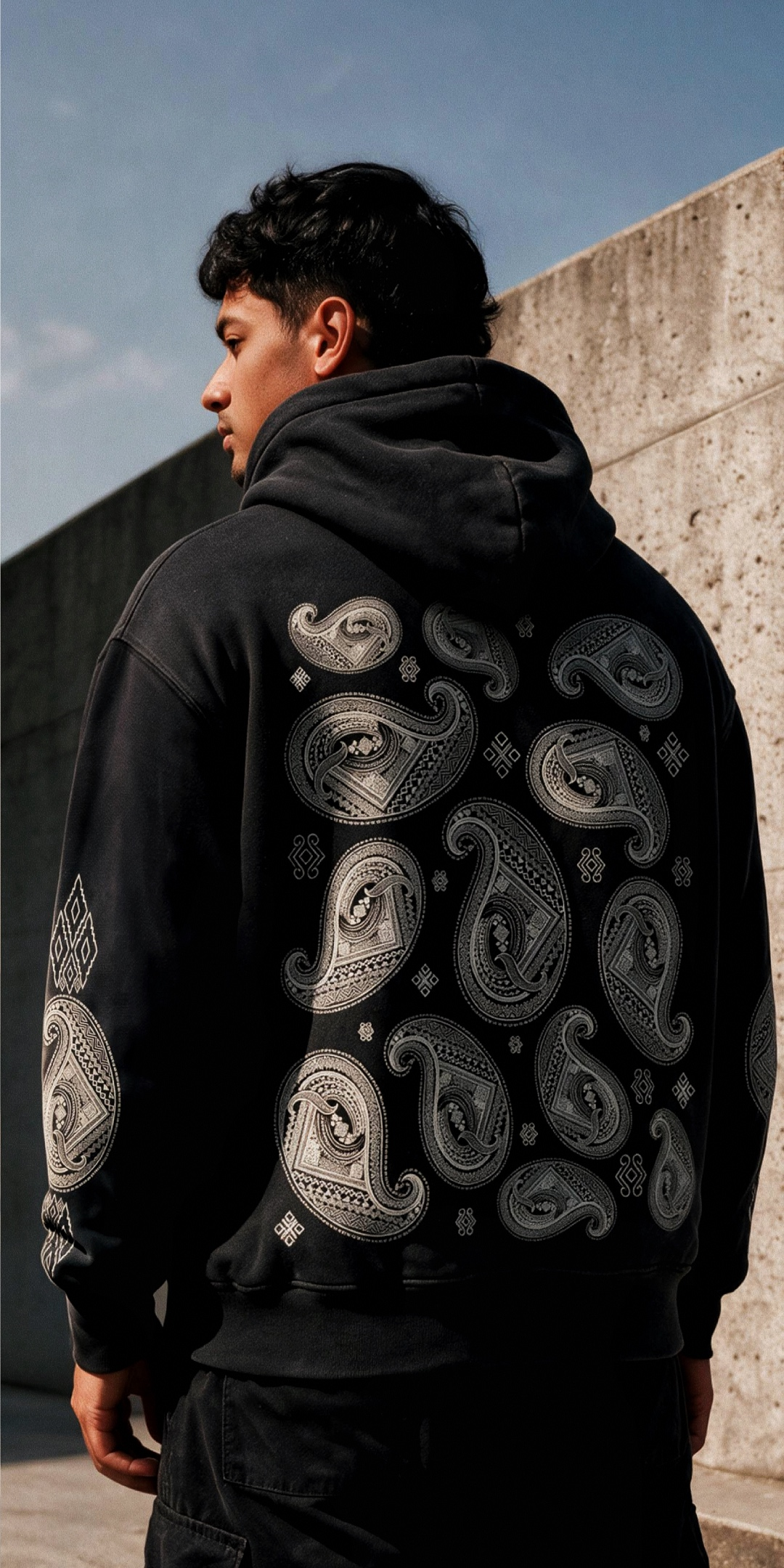 Man wearing a Diocelo tee, standing against a concrete stairway